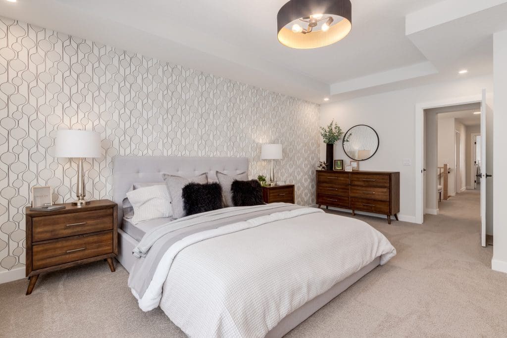 Crimson Ridge Showhome Master Bedroom with funky wallpaper and dark wood accent furniture